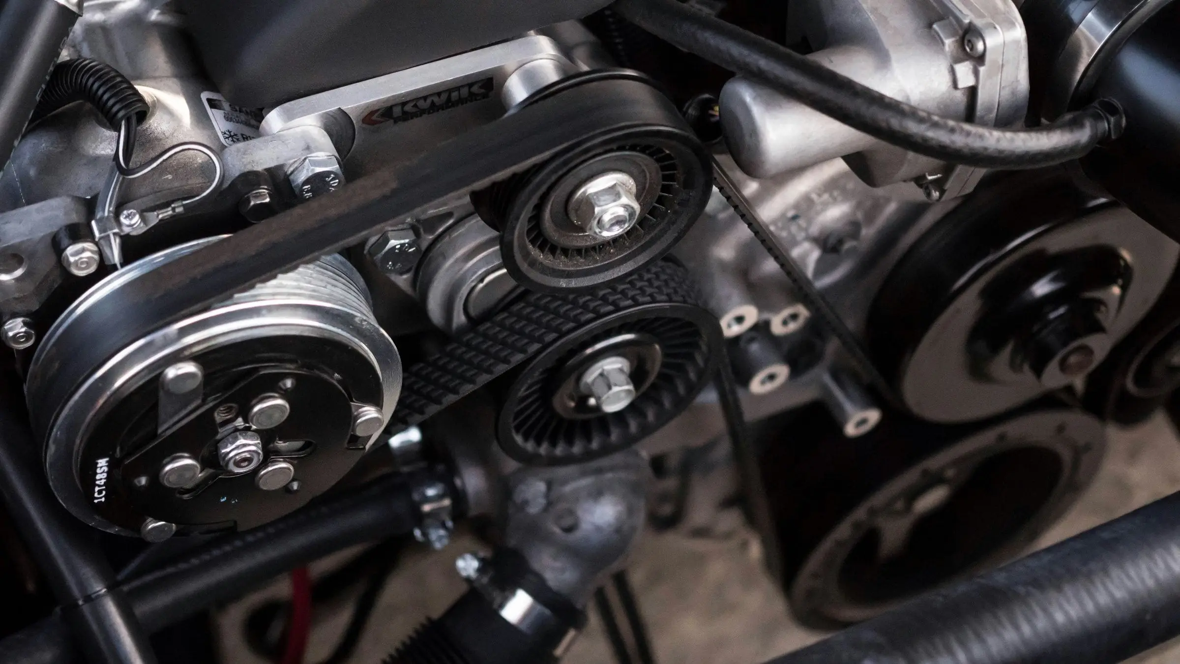 Detalle de un motor de coche con las correas y poleas a la vista